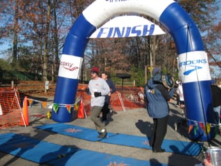 Chris crossing the finsh line at the Greensboro Gobbler 5K