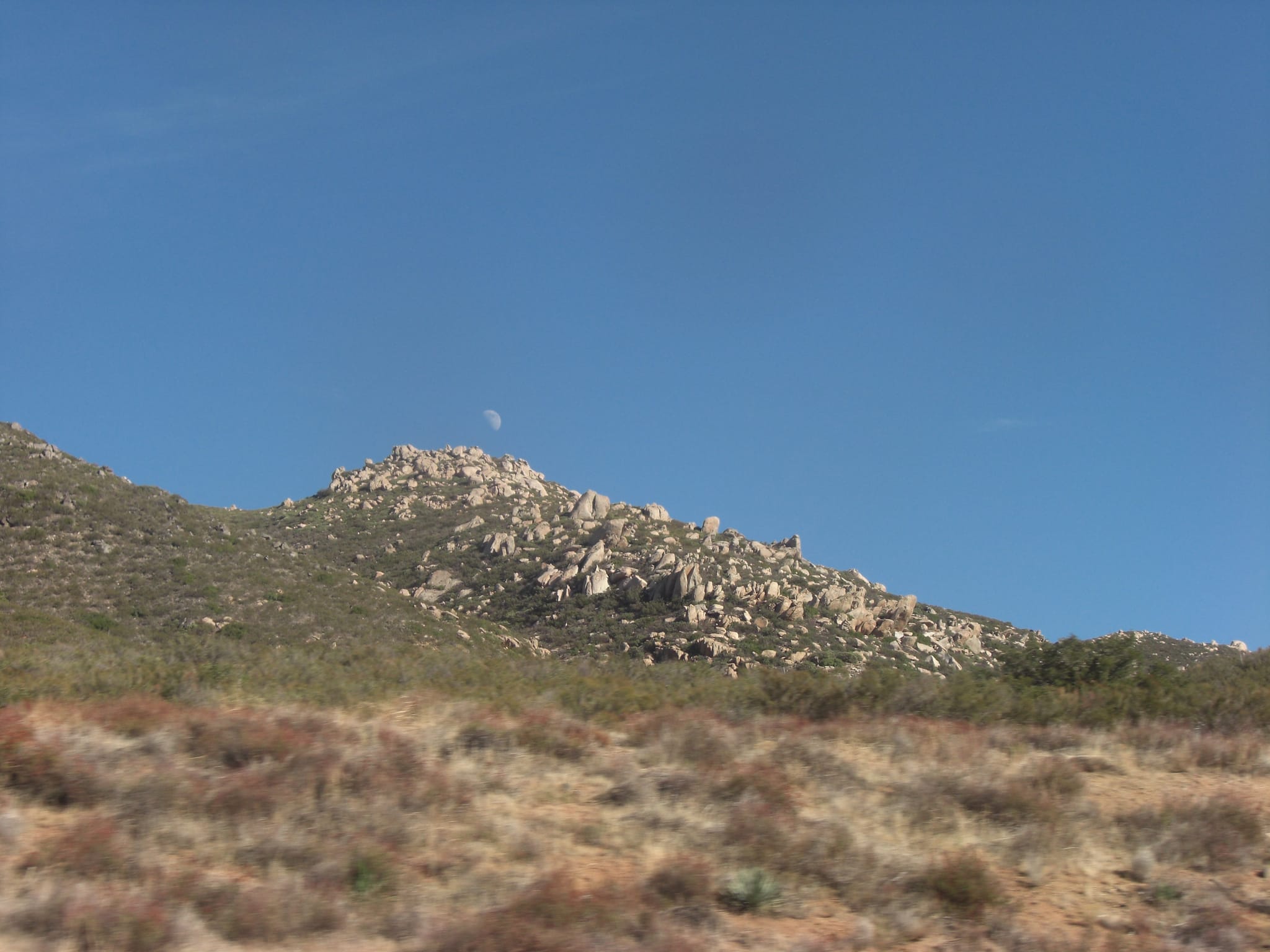 Moon over rocky terrain