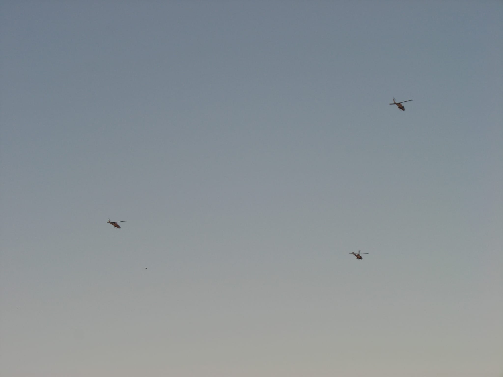Three military helicopters passing over in Yuma, AZ