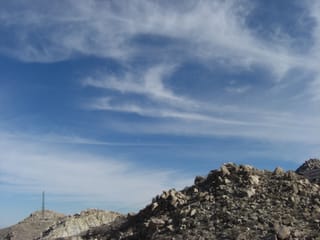 Wispy clouds over rocky desert