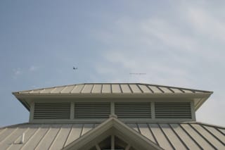 Plane over building with sign