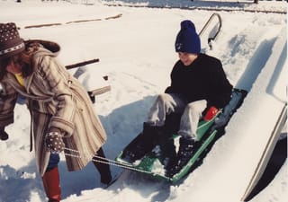 Mom pulling Chris down the snow slide